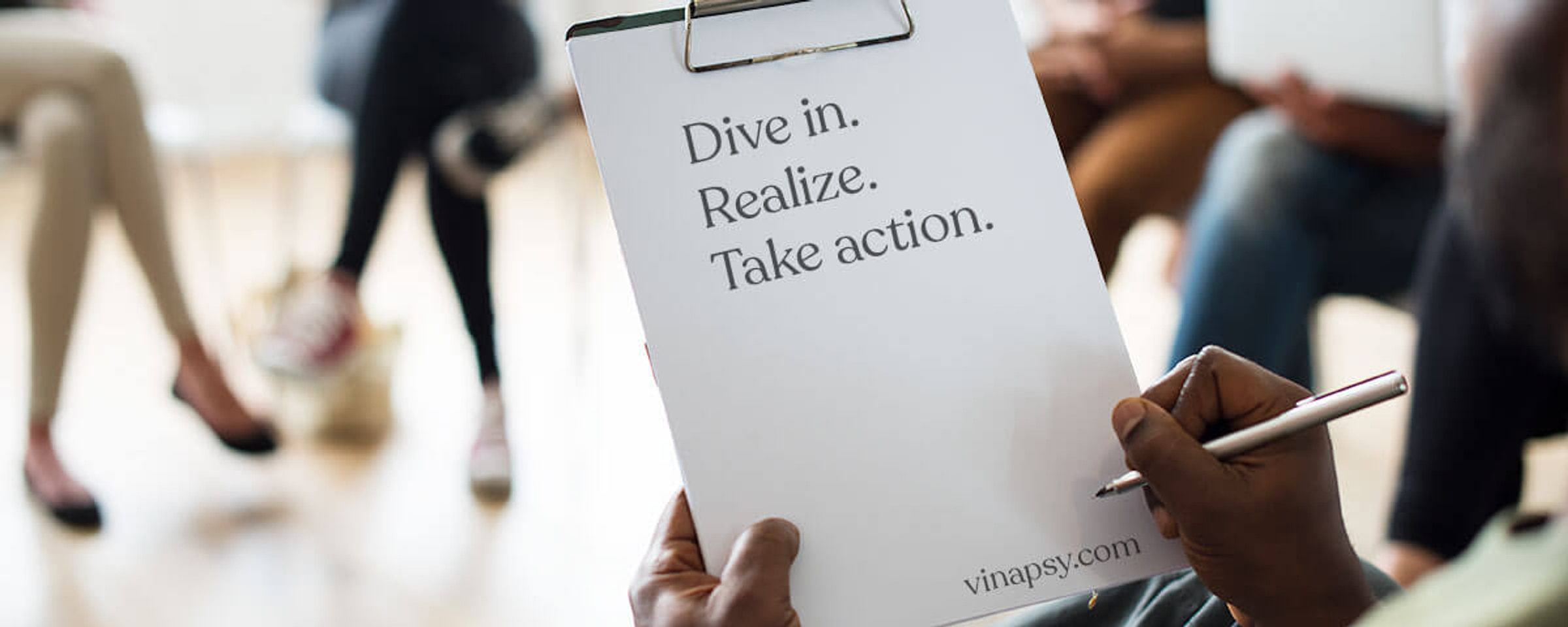 A person holding a VINAPSY brochure at an event.