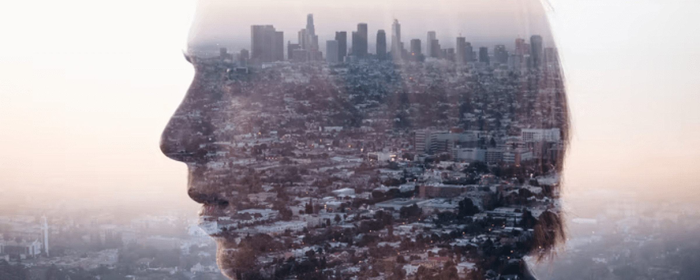 A person’s profile blended with a city landscape.