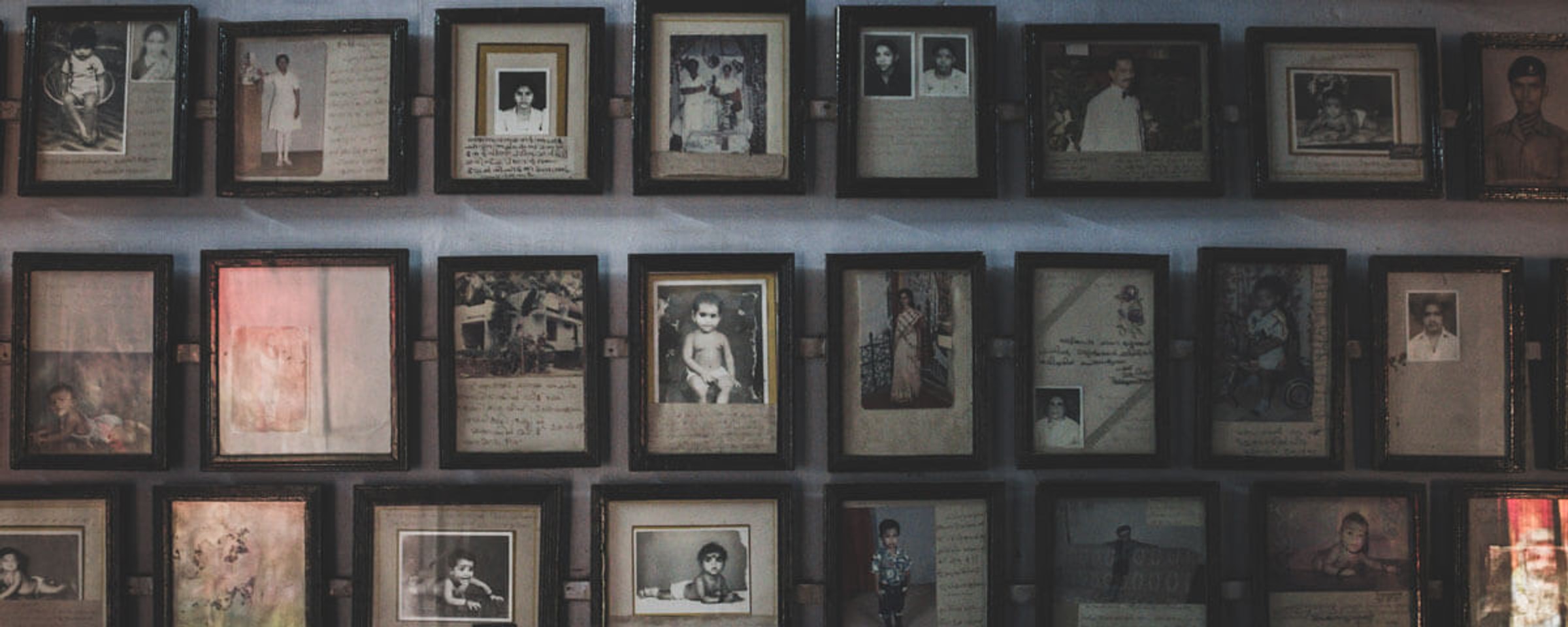 A wall covered with framed portraits from different eras.