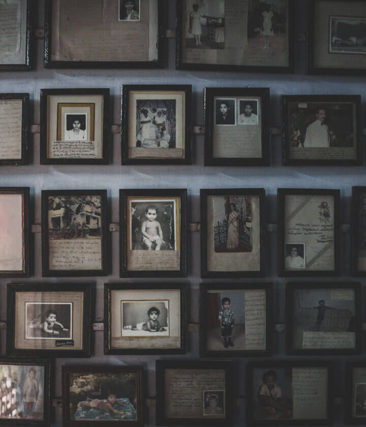 A wall covered with framed portraits from different eras.