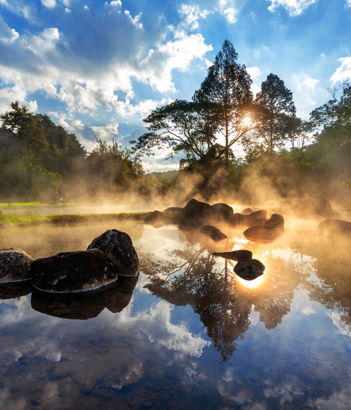 Morning sunlight and mist over a rocky woodland stream.
