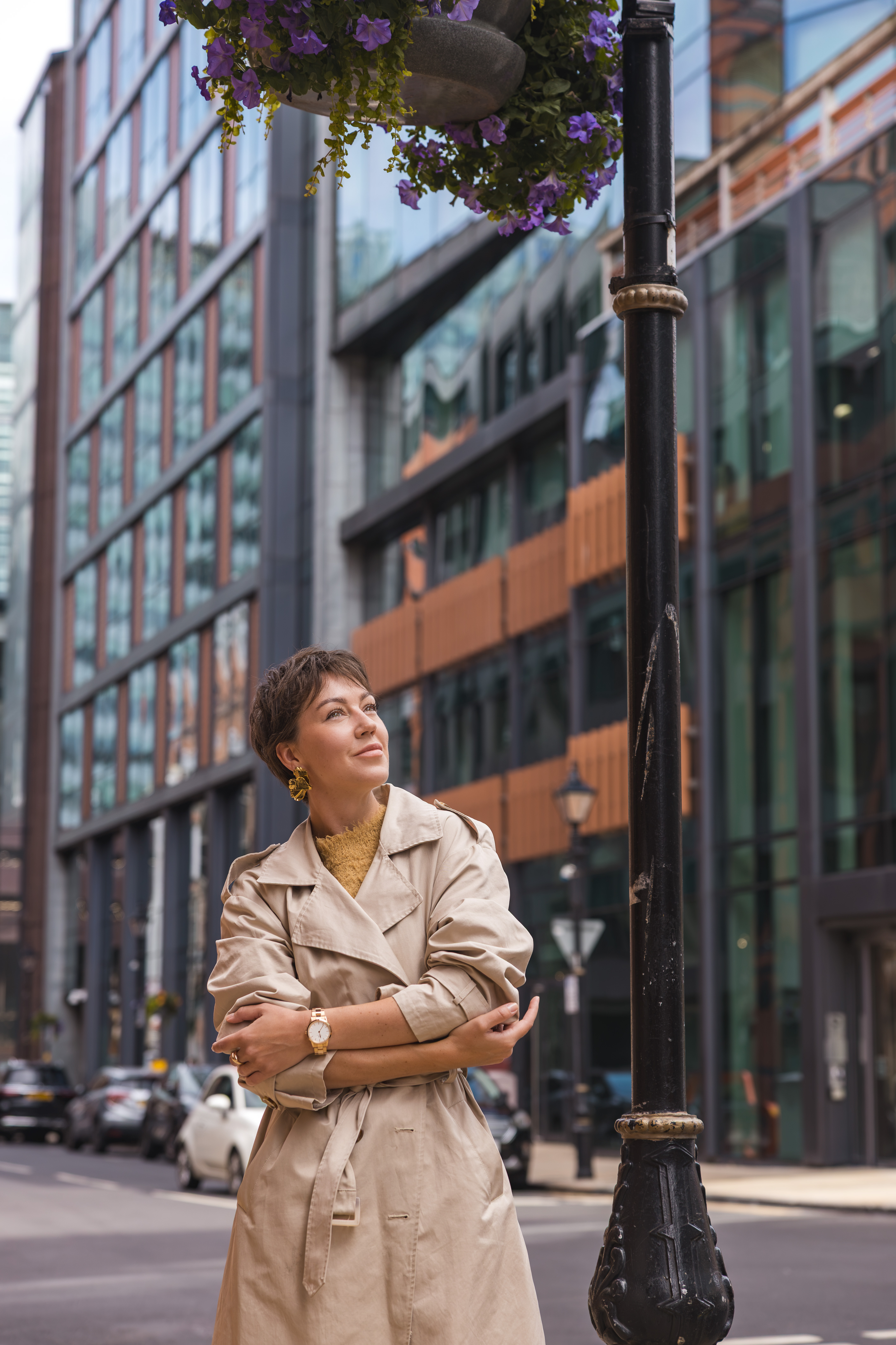 Viktoria Loginova in a beige trench coat on a city street.