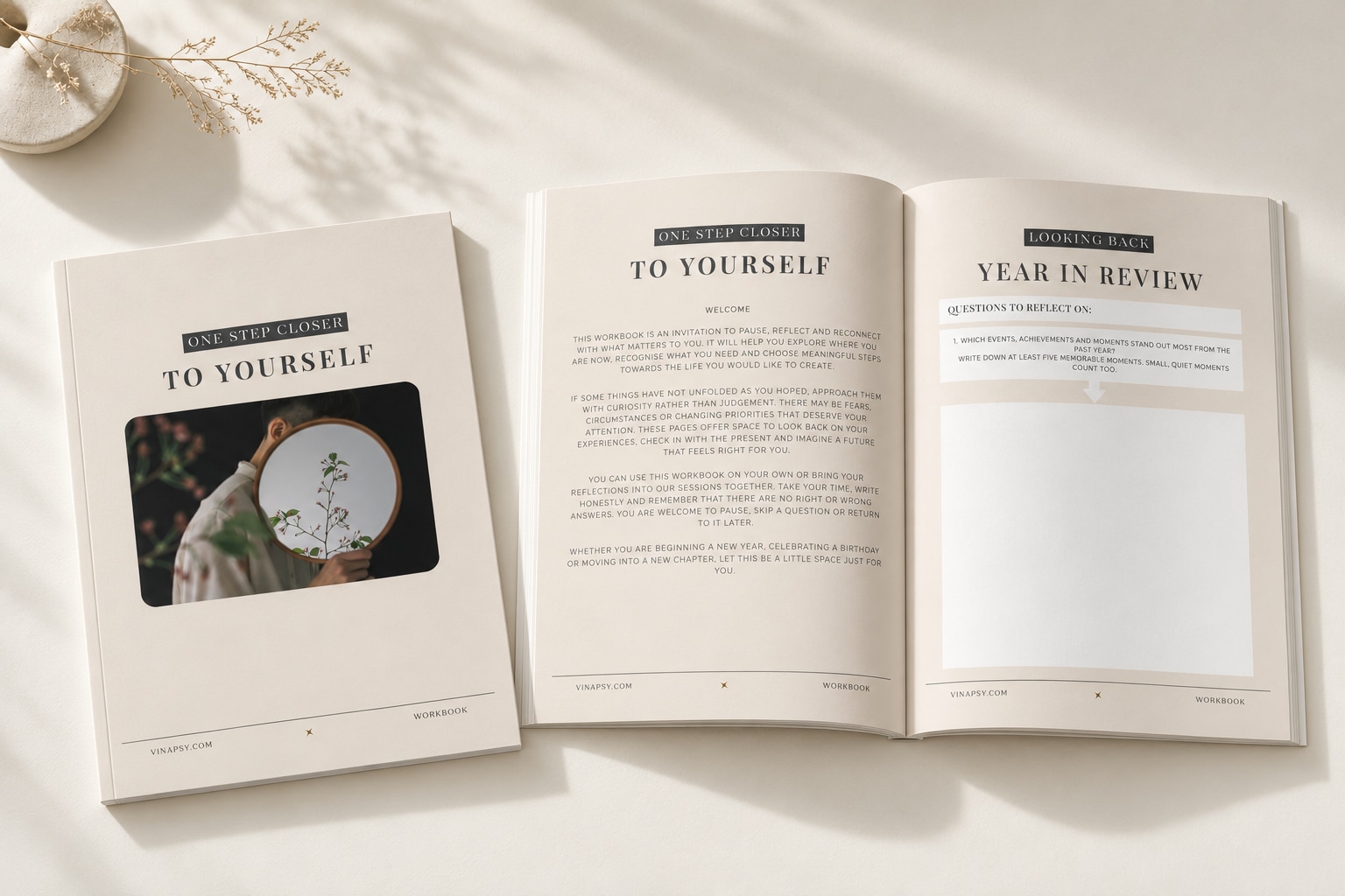 The workbook cover and an open spread on an ivory table in soft daylight.